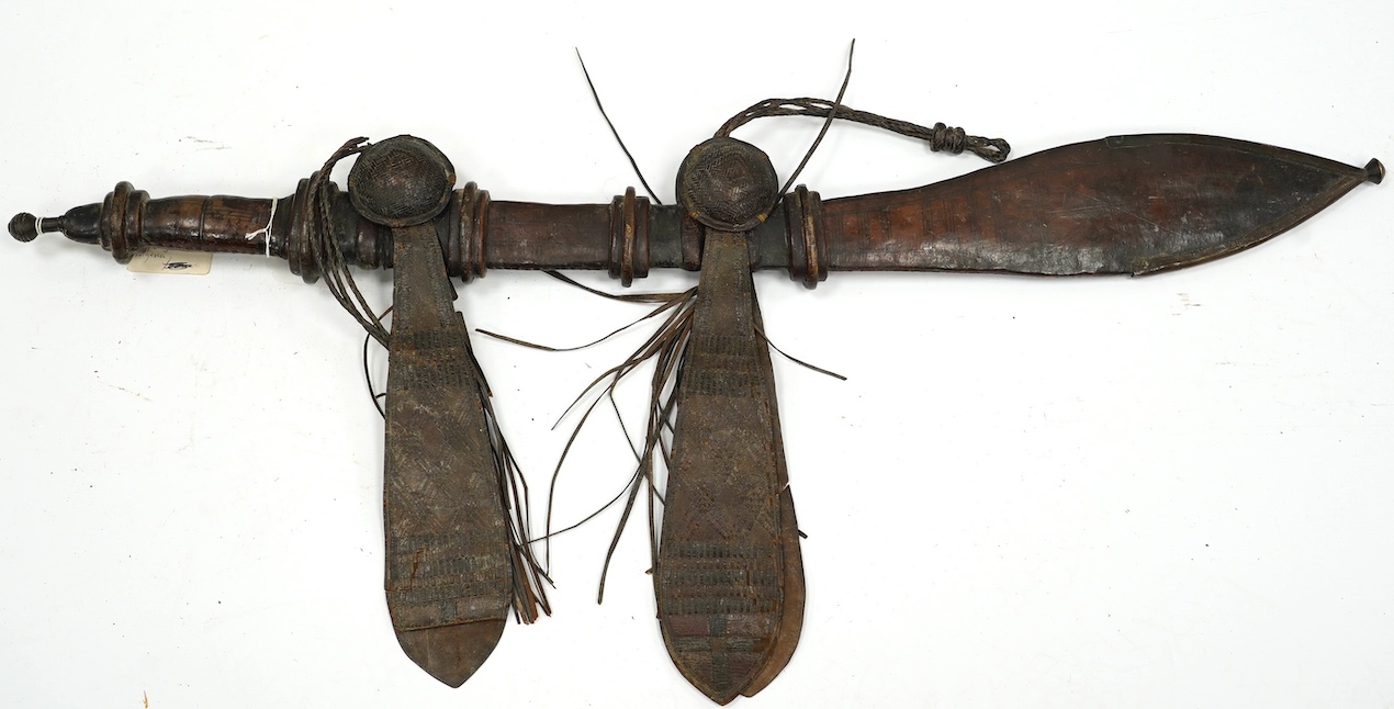 A late 19th century Nigerian Taboura from the Hausa People of Northern Nigeria, in leather scabbard, blade 55.5cm. Condition - good